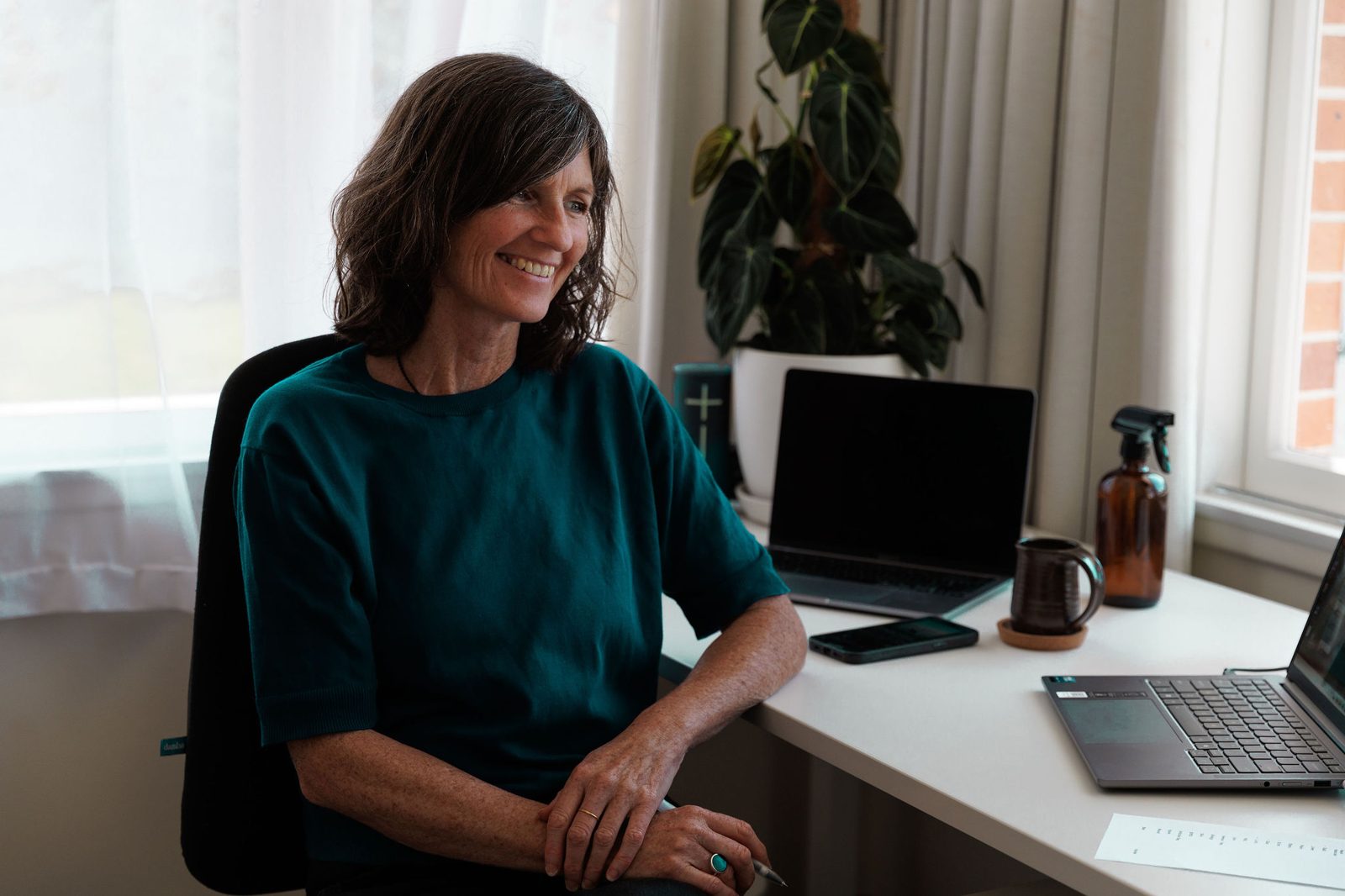 Caroline smiling at her desk in the home studio